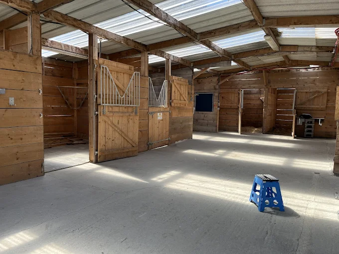 Intérieur des écuries d'Oska, allée centrale et boxes en bois